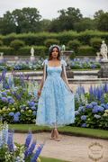 Modelo africana con vestido azul en jardín Versailles